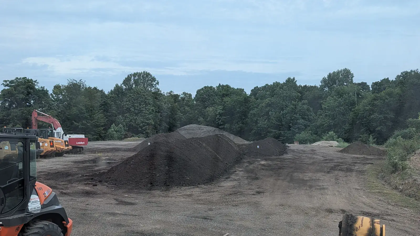 Loader and stockpiles of dark screened material at the O'Bryan yard in Stow, Ohio